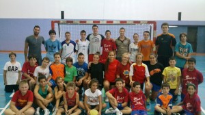 Los cuatro jugadores del Cangas junto a los participantes en el campus de balonmano.