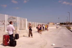 Los turistas esperan taxi en el puerto bajo un sol de justicia