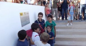 Varios niños posan junto a la placa conmemorativa de la inauguración de las instalaciones.