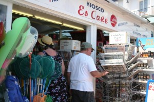 Dos turistas ojean algunos artículos en el Kiosko Es Cañé.