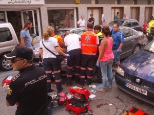 La chica es atendida por los médicos encima del coche sobre el que cayó