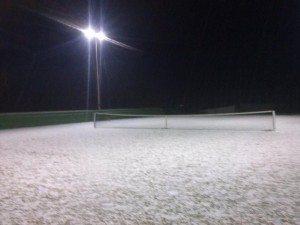 Una pista de tenis cubierta completamente de un manto blanco.