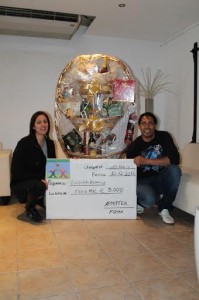 La presidenta de Apmiptea y el ganador del sorteo posan con el premio. 