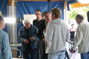 El director de cine da instrucciones al actor Max Riemelt con Luciano Tovoli a su costado. 