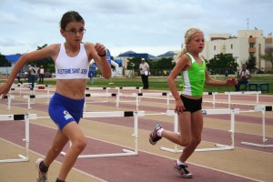 Dos atletas toman parte en una prueba de vallas en una competición insular.