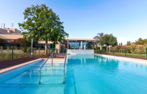 La piscina exterior de Sa Residència con los apartamentos en venta al fondo.