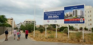 Imagen del solar, la calle peatonal de acceso al futuro aparcamiento y el cartel promocional instalado