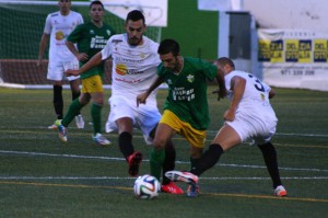 Un jugador del Atlético Rafal se lleva el balón ante la presión de dos rivales.