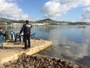 Un policía local en la terraza del bar Flotante, junto a la zona de la bahía donde se ha roto el emisario submarino.   Foto: L. A.