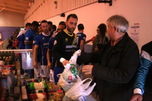 Los jugadores del Gasifred entregan una bolsa de comida cada uno antes del partido. Fotos: C. V.