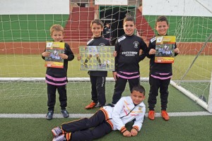 Varios jugadores de la Peña Deportiva muestran el álbum de cromos del club.