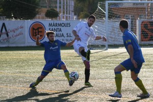 Pau Pomar pugna por el balón en defensa con dos jugadores del Penya Ciutadella.