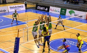 Edmon Solanas remata el balón ante el bloqueo de tres jugadores del Unicaja. Foto: Almería Voley