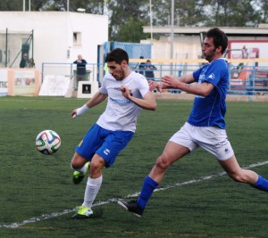 Buades despeja el balón ante la presión del delantero local Manolo.