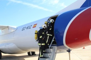 Los bomberos accediendo al avión supuestamente afectado por el vertido.