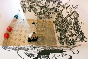 Sara Fratini pintando toda una habitación con sus heroínas curvilíneas y melenudas.  Foto: (c) Maki Ochoa