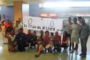 Varias de las personas que recibieron al deportista posan junto a la pancarta hecha para la ocasión.