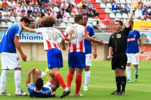 El colegiado Cuestas García enseña la cartulina a un jugador local.