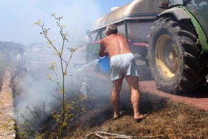 Varios vecinos ayudan a a pagar las llamas durante el incendio de esta tarde. Fotos: Ramón Tur