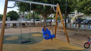 Imagen del columpio adaptado instalado en el parque infantil de paseo marítimo. 