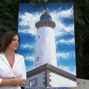 Cristina Ferrer, junto a uno de los cuadros de la exposición en el Faro de ses Coves Blanques.