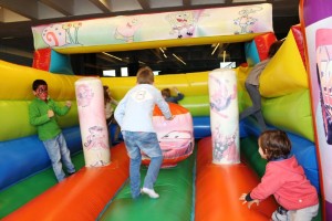 Seis niños se lo pasan en grande jugando en el castillo hinchable.