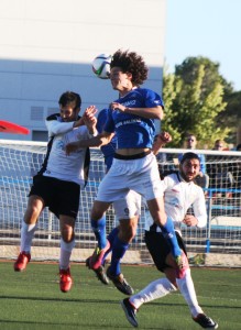 Gady salta por el balón ante un jugador rival.