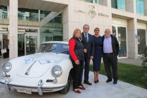 Vicent Torres y Marta Díaz posan junto a los organizadores del rally y uno de los vehículos participantes.