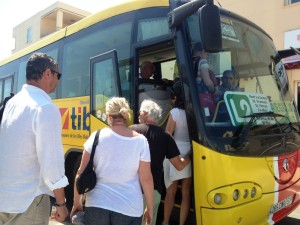 Varios pasajeros suben al autobús en una parada de Formentera.