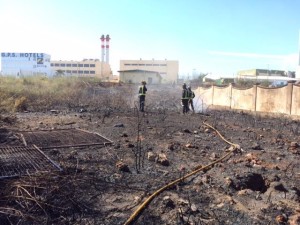 Los bomberos refrescan la zona afectada por el fuego. 