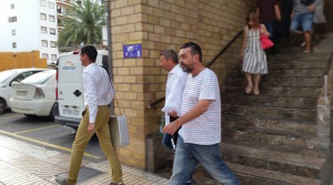 En primer plano el contable de la discoteca junto a Martín Ferrer, con camisa blanca y vaqueros azules, a la salida del juzgado.