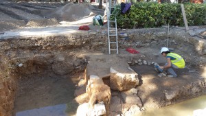 El muro encontrado en la Plaza del Parque durante las obras, rodeado de agua. 